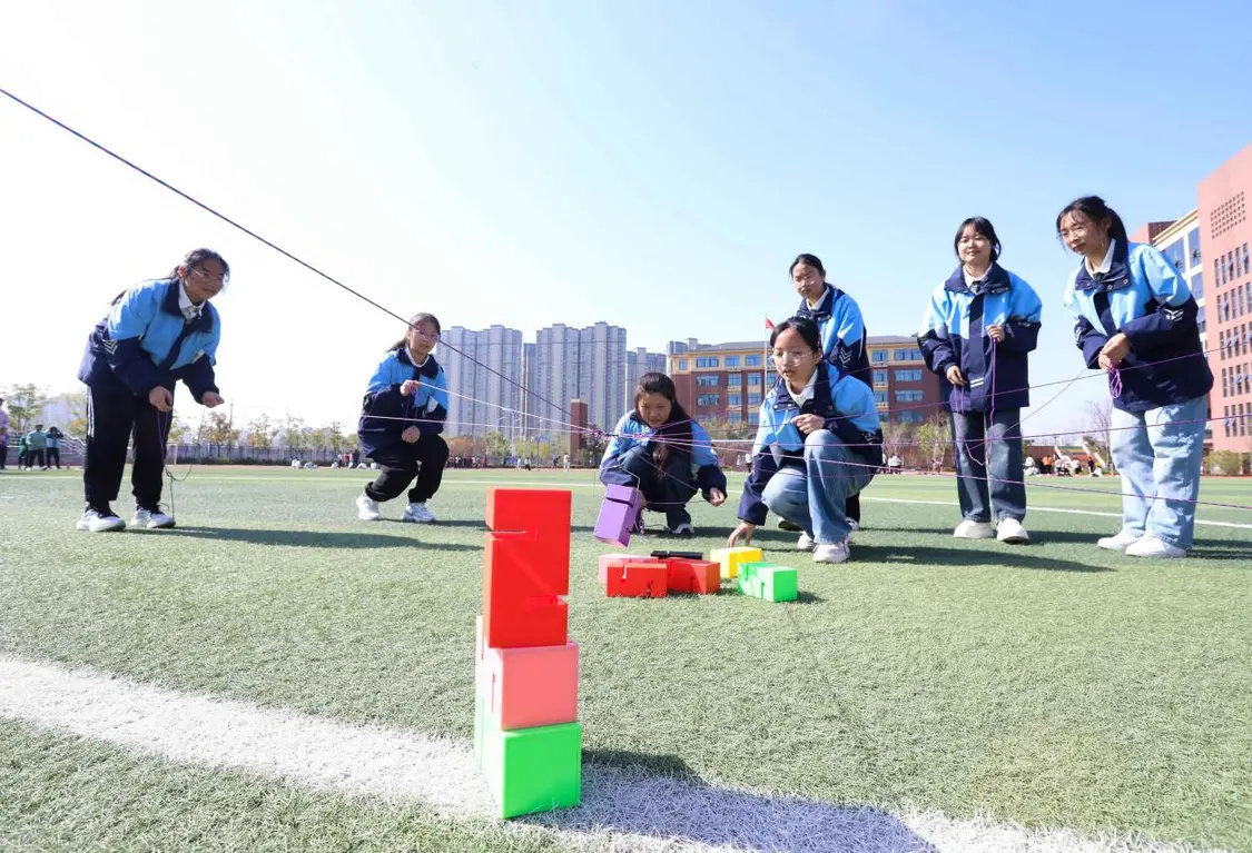 （图为：2025年3月25日，在安徽省合肥市肥西县上派镇安徽师范大学附属肥西第二中学校园内，学生们利用阳光大课间时间在操场上召开“合力筑塔”心理团辅游戏。）