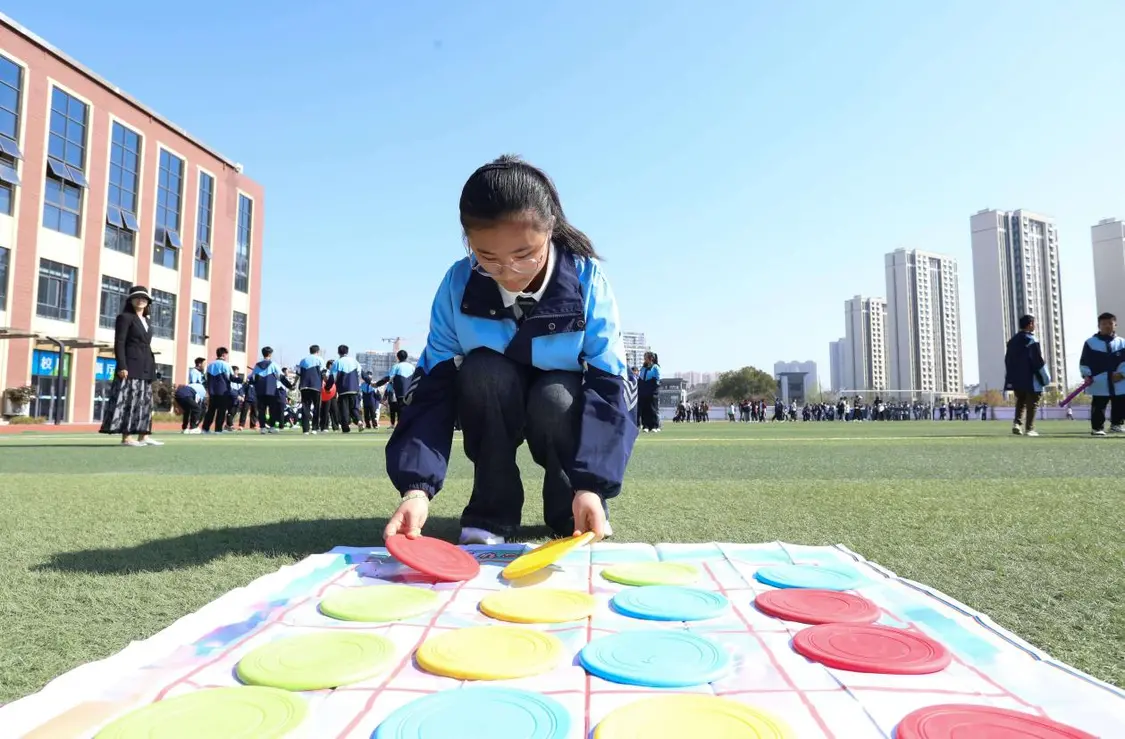 （图为：2025年3月25日，一名学生在安徽省合肥市肥西县上派镇安徽师范大学附属肥西第二中学操场上召开“彩色移盘”心理团辅游戏。）