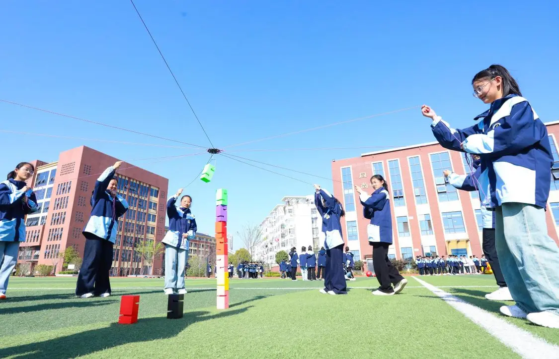 （图为：2025年3月25日，在安徽省合肥市肥西县上派镇安徽师范大学附属肥西第二中学校园内，学生们利用阳光大课间时间在操场上召开“合力筑塔”心理团辅游戏。）